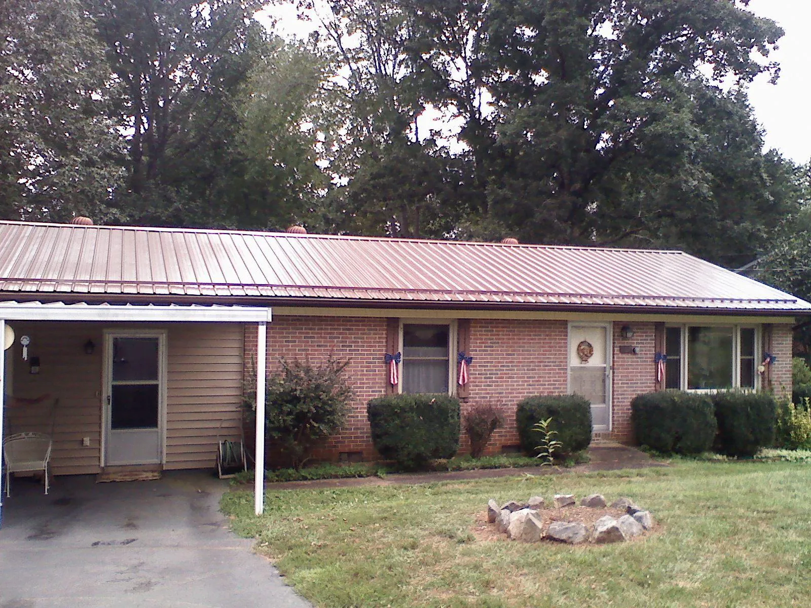 Bronze metal roof and carport on a brick ranch home in Cambridge